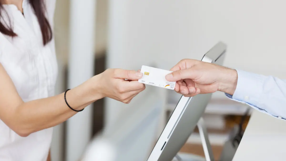Patientin zeigt ihre Krankenversichertenkarte vor