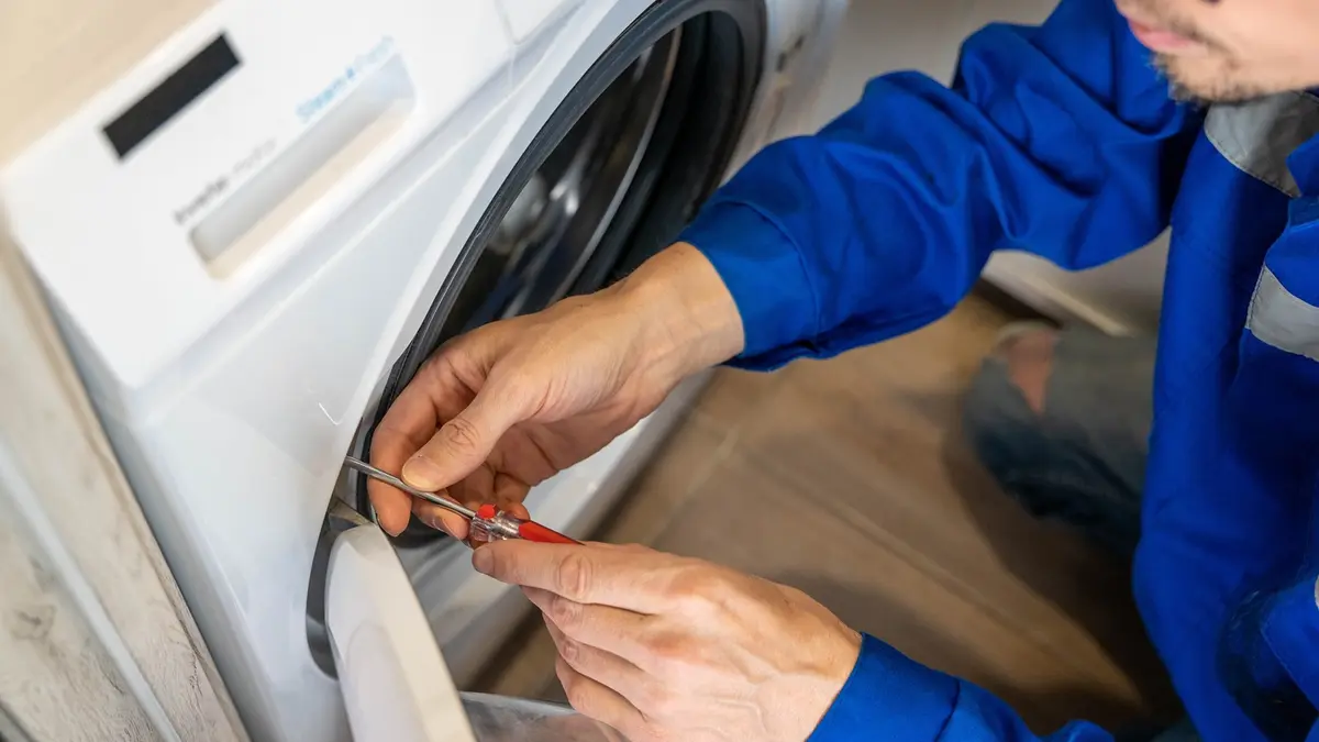 Ein Installateur repariert eine Waschmaschine 