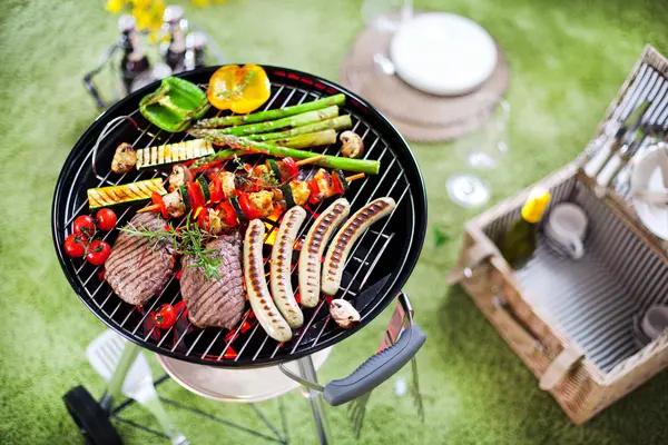 Grillfleisch und Grillgemüse auf dem Grill im Garten