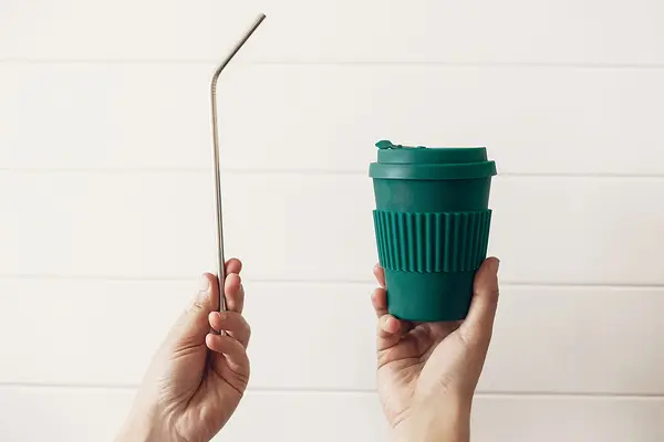 Ein wiederverwendbarer Trinkhalm und ein Coffee-to-go-Becher aus Bambus