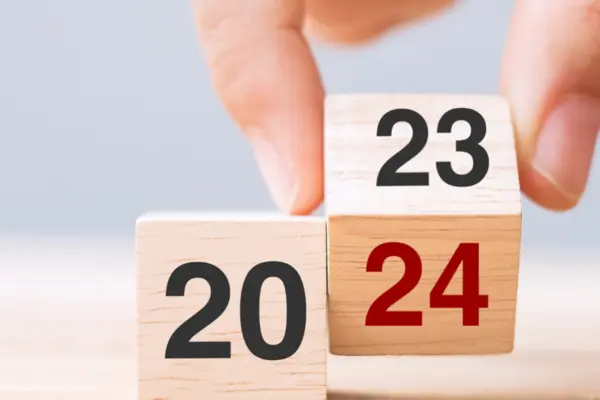 Hand wechselt Kalender von 2023 auf 2024