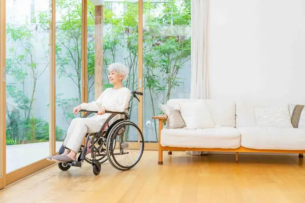 Frau im Rollstuhl schaut in den Garten