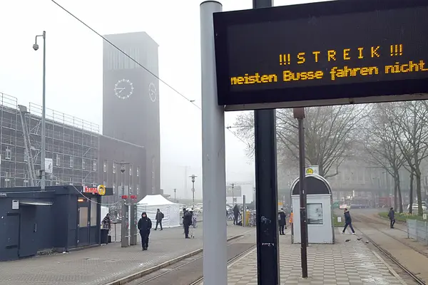 Straßenbahnhaltestelle mit digitalem Hinweisschild: "STREIK!"