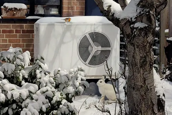 Wärmepumpe im Schnee vor Hauswand