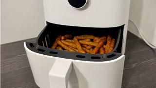 Eine geöffnete Heißluftfritteuse mit Blick auf frittiertes Gargut. 