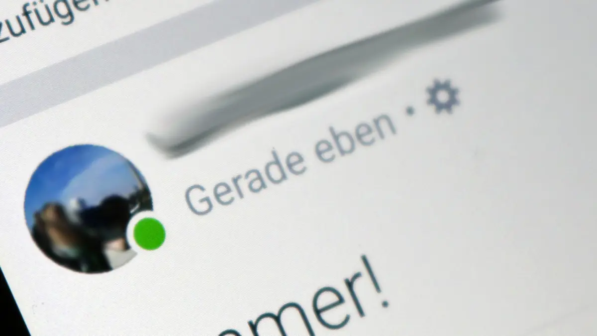 Ein grüner Punkt am Profilbild eines Facebook-Nutzers schräg von einem PC-Bildschirm fotografiert