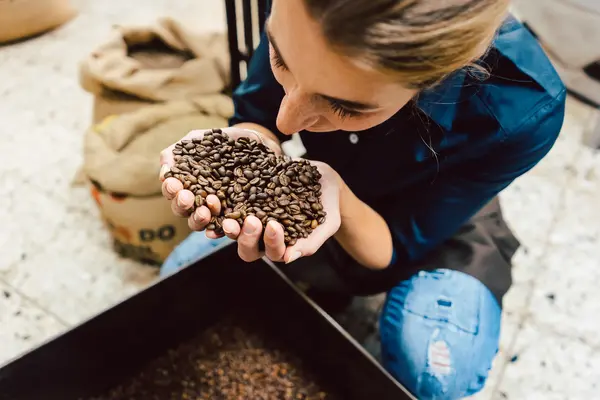 Frau riecht an Kaffeebohnen