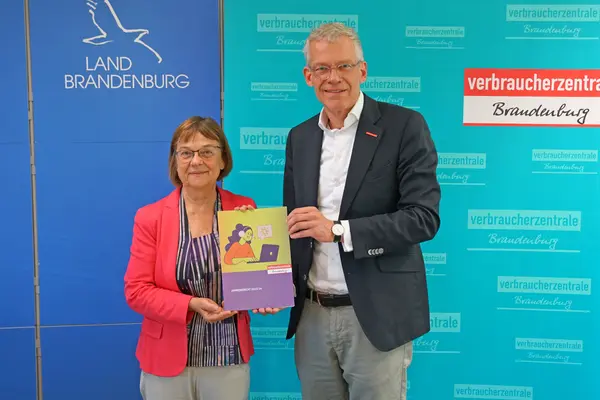 Christian A. Rumpke, Chef der Verbraucherzentrale Brandenburg, übergibt Verbraucherschutzministerin Ursula Nonnemacher den Jahresbericht 2023/24