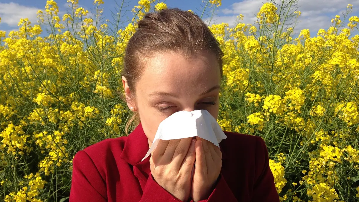 Frau mit Allergie putzt sich die Nase