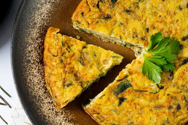 Frittata mit einem Stück herausgeschnitten auf einem Teller