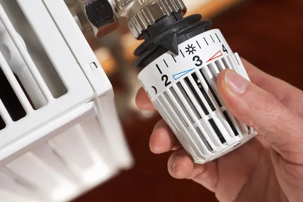 Verbraucher dreht seine Heizung am Thermostat auf Stufe 3