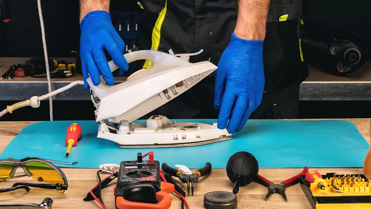 Handwerker beim Reparieren eines Bügeleisens