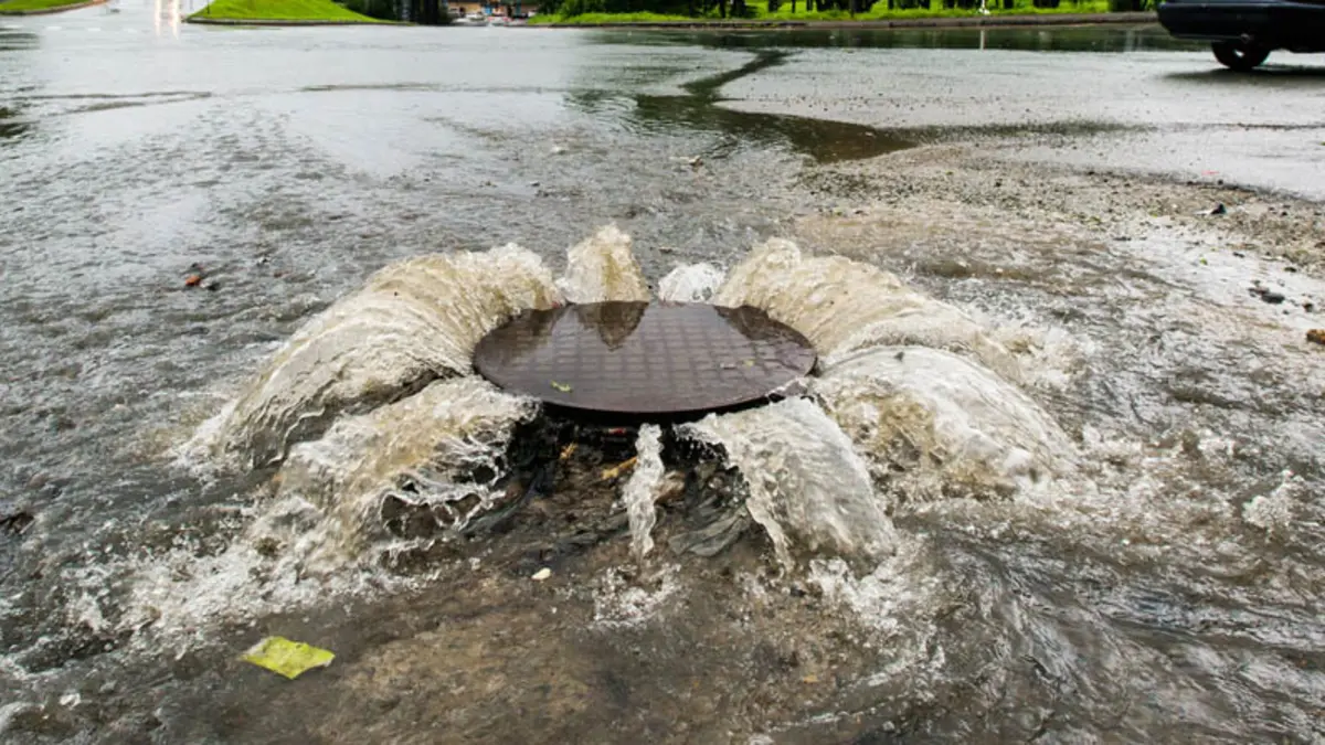Wasser dringt aus einem Gulli nach oben