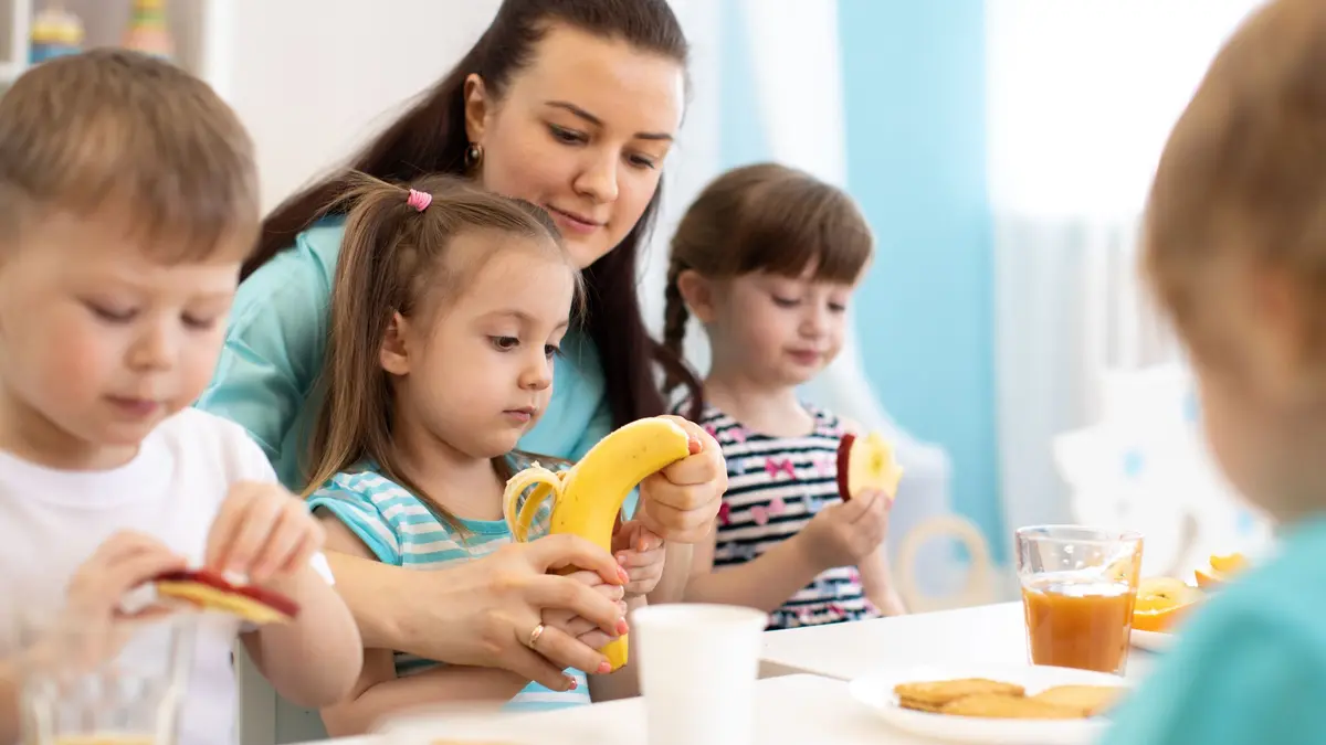 Kinder sitzen am Tisch und essen