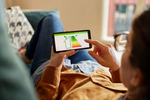 Frau checkt Energieeffizienz auf ihrem Handy