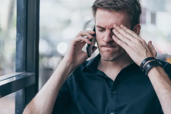 Mann am Telefon guckt gestresst