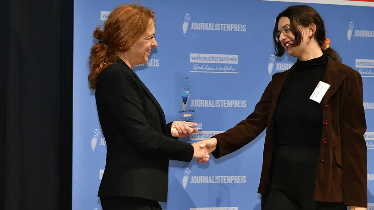 Jurymitglied mit Gewinnerin auf der Bühne