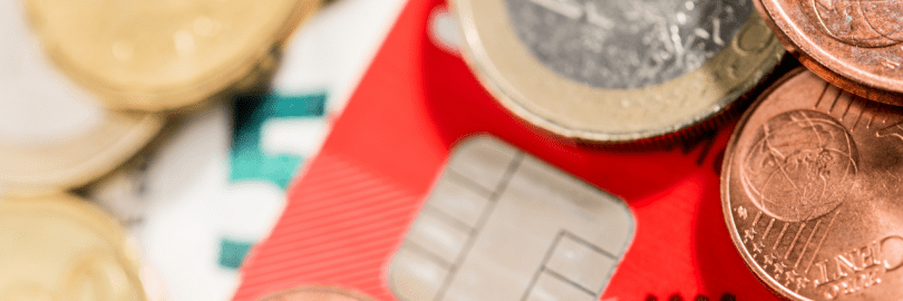 Geldmünzen liegen auf einer Kreditkarte