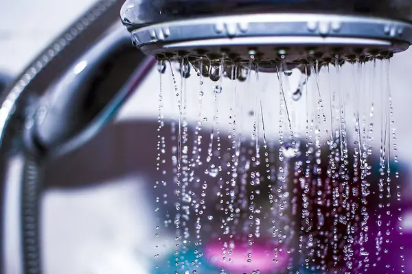Nahaufnahme Duschkopf mit laufendem Wasser
