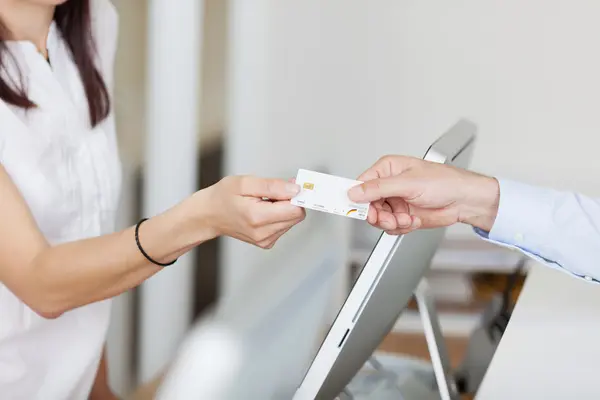 Patientin zeigt ihre Krankenversichertenkarte vor