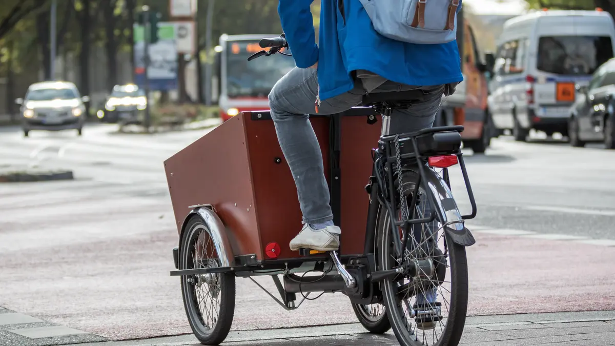 Ein Mann fährt auf einem Lastenfahrrad
