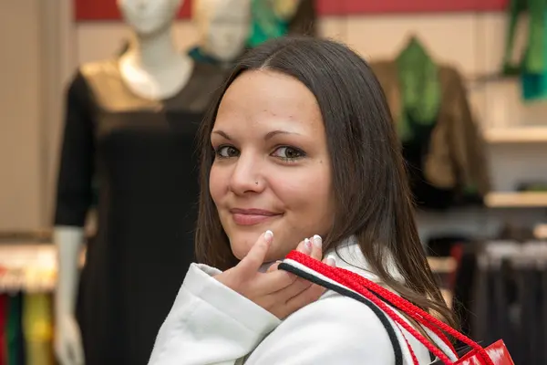 Junge Frau beim Shopping, trägt mehrere Tüten über der Schulter 
