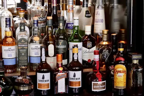 Mehrere Flaschen Alkohol stehen in einer Bar nebeneinander.