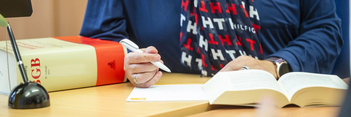 Ein BGB liegt vor einer Beraterin auf einem Schreibtisch.