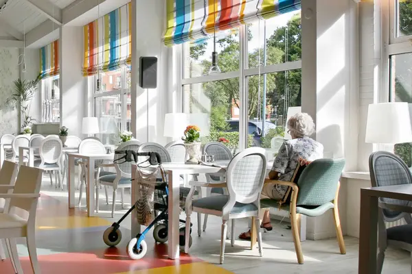 Eine Seniorin sitzt alleine in einem Café