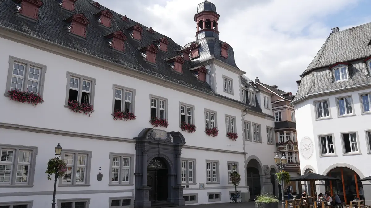 Ein großer Platz umrundet von einem großen Gebäude.