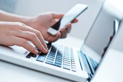 Nahaufnahme von jemandem, der Laptop und Smartphone nutzt