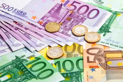 Große Euro-Scheine und Münzen liegen aufeinander.