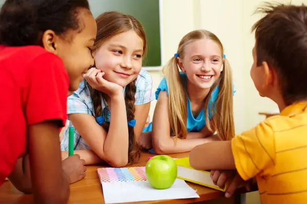 vier Kinder sitzen lachend am Tisch