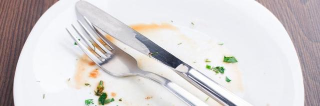 Ein leerer Teller auf dem Besteck liegt