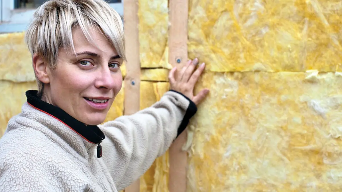 Junge Frau vor frisch gedämmter Wand
