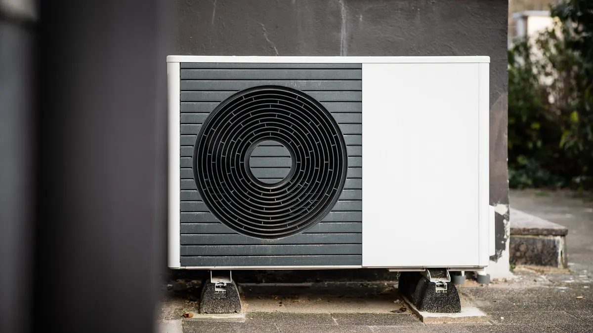Eine Wärmepumpe steht vor einer Hauswand