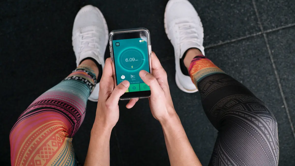Sportmensch hält Fitness-App in der Hand