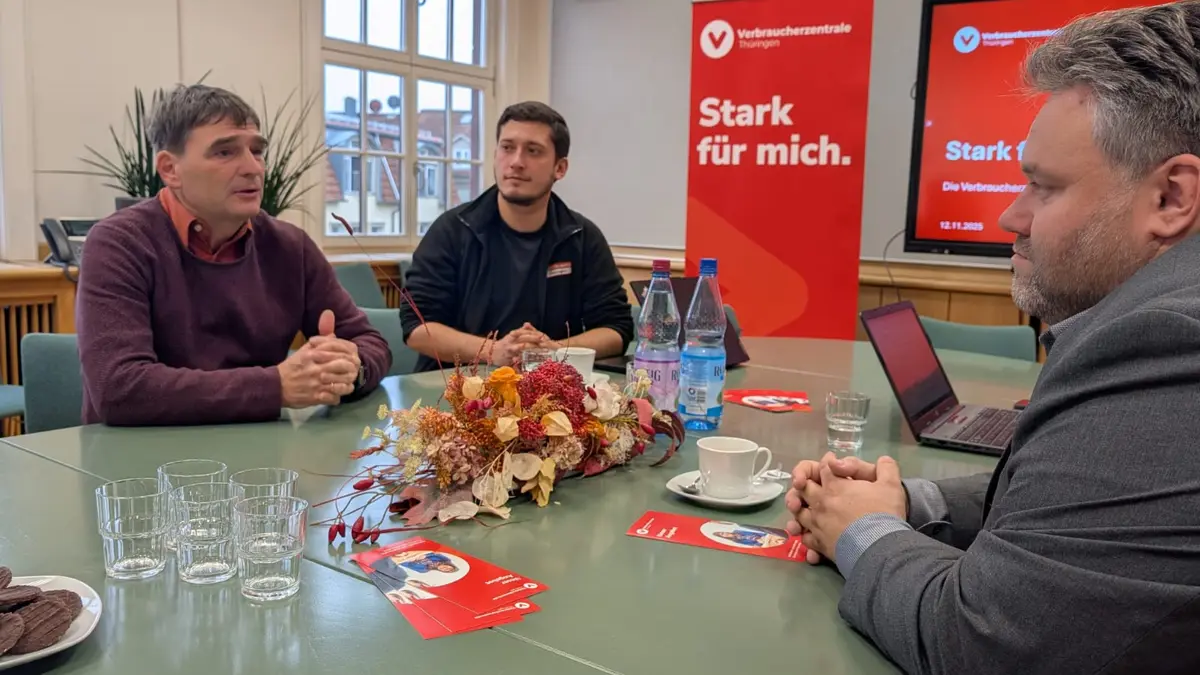 Die Teilnehmenden an der Eröffnung sitzen an einem Tisch und unterhalten sich.