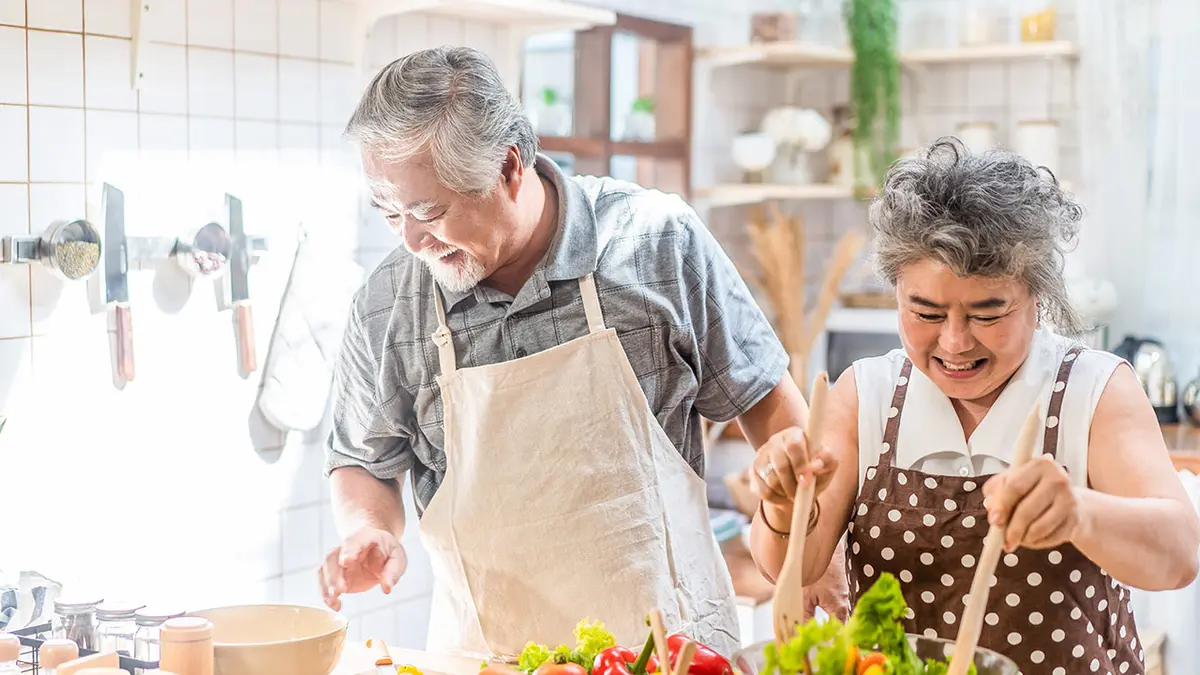 Senioren aus Asien kochen zusammen in der Küche gesund