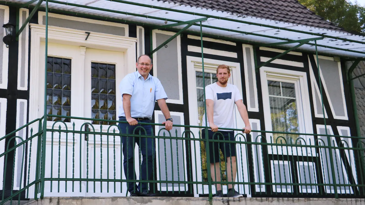 Energieberater Carsten Peters mit Verbraucher Jan Blefgen vor seinem Fachwerkhaus