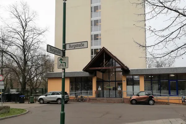 Auf dem Foto ist der Haupteingang der Josephinen-Wohnanlage abgebildet. Davor ist das Straßenschild mit der Aufschrift Burgstraße zu sehen.