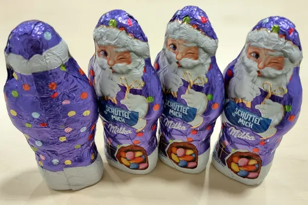 Vier Milka-Schokoweihnachtsmänner nebeneinander