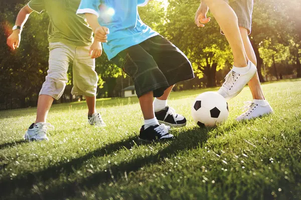 Jungen spielen Fußball auf der Wiese