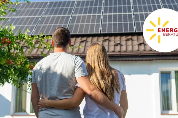 Junge Paar schaut auf ein Hausdach mit Photovoltaik