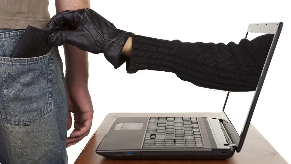Aus einem Laptop kommt eine behandschuhte Hand und klaut einem Mann den Geldbeutel aus der Hosentasche.