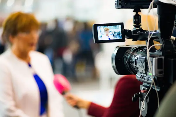 Person wird von Presseteam vor Kamera interviewt.
