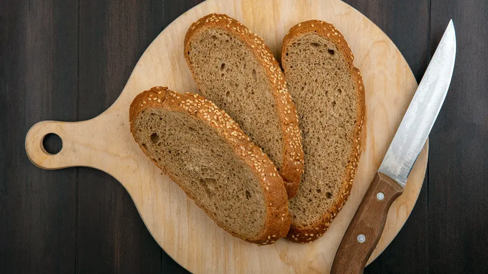 Brotscheiben und ein Messer auf einem Schneidebrett
