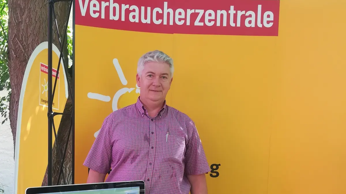 ein mann vor dem Plakat der Verbraucherzentrale