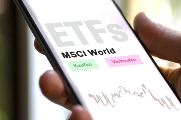 Eine Hand, die ein Smartphone hält, auf dem "ETFs, MSCI World" und "Kaufen" und "Verkaufen" zu lesen ist