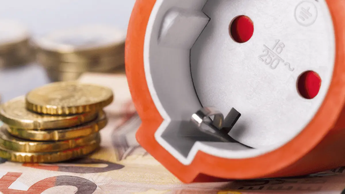 orangener Stecker liegt auf Bargeld